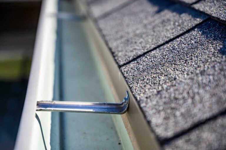 view inside roof gutter with clips and edge of shingles